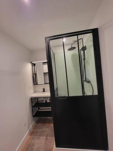 d'une porte en verre menant à une salle de bains pourvue d'un lavabo. dans l'établissement L'annexe de la verrerie, à Cognac