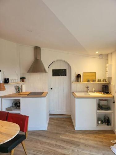 d'une cuisine avec des comptoirs blancs et une porte blanche. dans l'établissement L'annexe de la verrerie, à Cognac