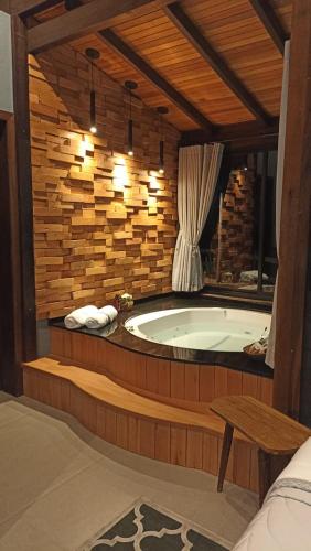 a bath tub in a room with a wooden wall at Refugio Grummel Wald in São Bonifácio