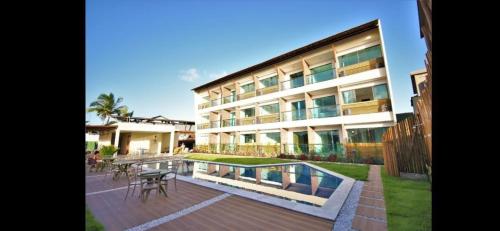 - un bâtiment avec une piscine en face dans l'établissement Condôminio Velas do Porto, à Porto de Galinhas