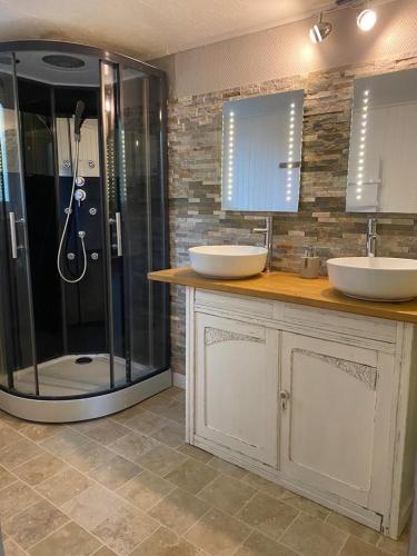 une salle de bain avec deux lavabos et une douche dans l'établissement Le Bellevue, à Dolmayrac