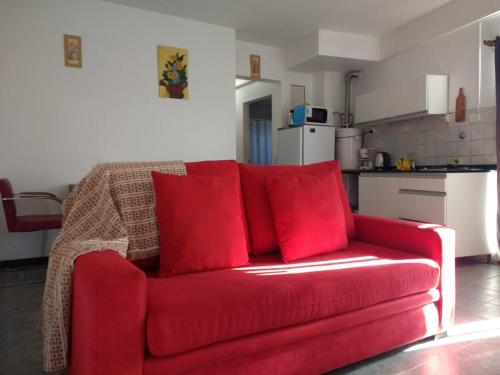 un sofá rojo con almohadas rojas en la cocina en Portal del Descanso en Buenos Aires