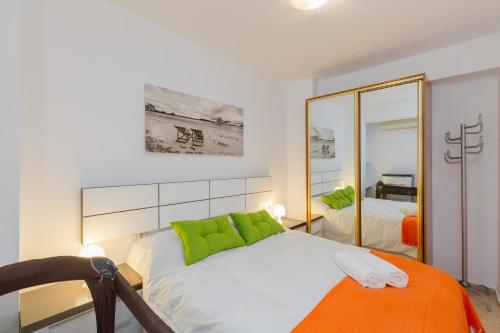 1 dormitorio con cama con almohadas verdes y espejo en Urban Chic by Fidalsa, en Alicante