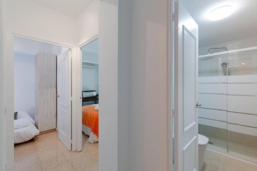 1 dormitorio con cama de color naranja y baño en Urban Chic by Fidalsa, en Alicante