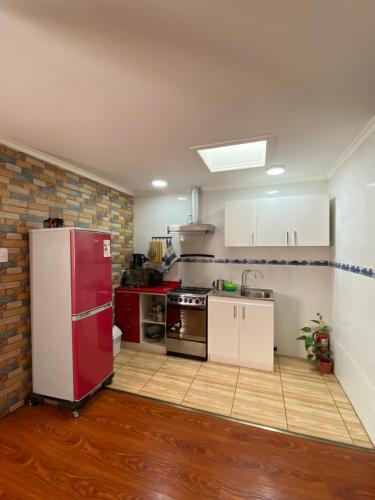 a kitchen with a red refrigerator in a room at Departamento amplio y cómodo in Iquique