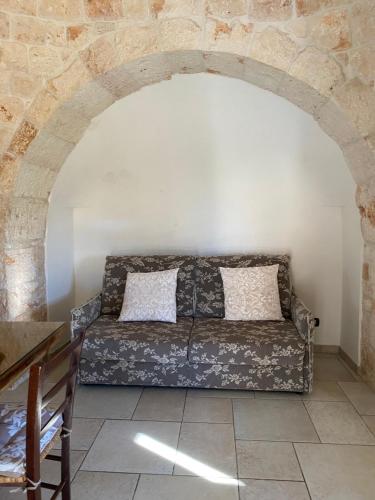 salon z kanapą w ceglanej ścianie w obiekcie Residenza Di Nonna Giulia w mieście Locorotondo