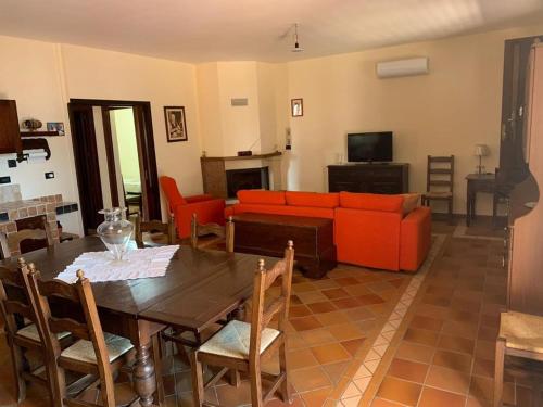ein Wohnzimmer mit einem Tisch und einem roten Sofa in der Unterkunft Villetta Girasole in Gallipoli