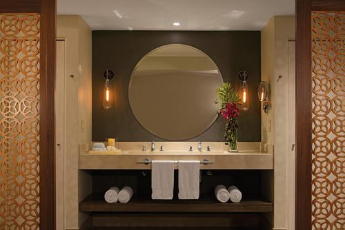 y baño con lavabo, espejo y toallas. en Secrets Papagayo All Inclusive - Adults Only en Culebra