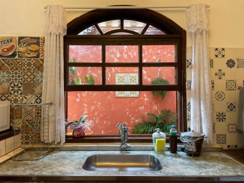 um lavatório de cozinha com uma janela numa cozinha em Pouso Da Mari em Tiradentes