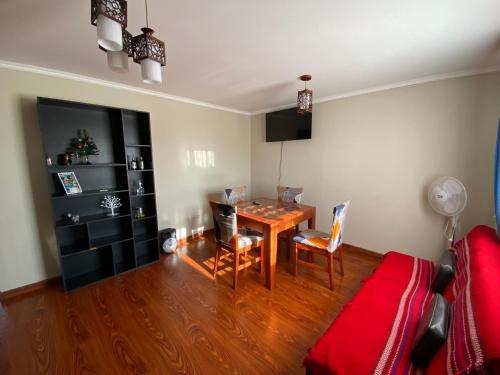 a living room with a table and a red couch at Departamento amplio y cómodo in Iquique