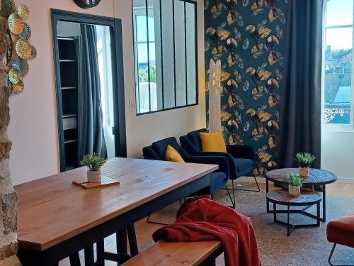un salon avec une table et des chaises en bois dans l'établissement tourmaline, à Concarneau
