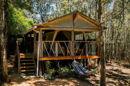 a tree house with a hammock in the woods at HighlandsView in Swellendam