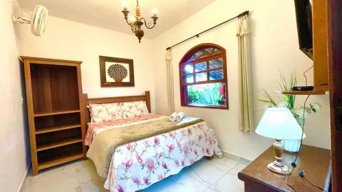 een slaapkamer met een bed en een raam bij Pouso Da Mari in Tiradentes