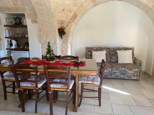 a dining room with a table and chairs and a couch at Residenza Di Nonna Giulia in Locorotondo