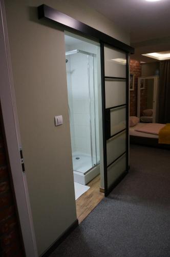 Pokój z przeszklonymi drzwiami prowadzącymi do sypialni w obiekcie Pokój Miejski w Zielonej Górze