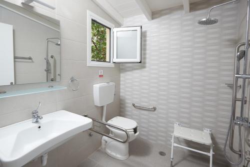 bagno con lavandino, servizi igienici e finestra di Klonos Anna a Città di Egina