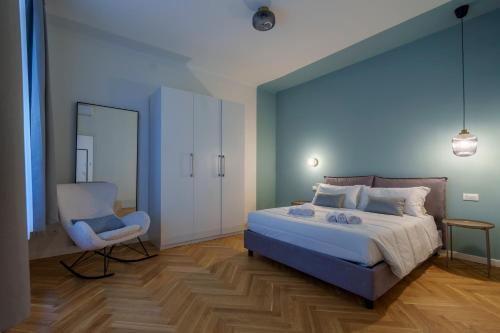 um quarto com uma cama, uma cadeira e um espelho em [DUOMO-PORTA VENEZIA]LUXURY WIFI E NETFLIX em Milão