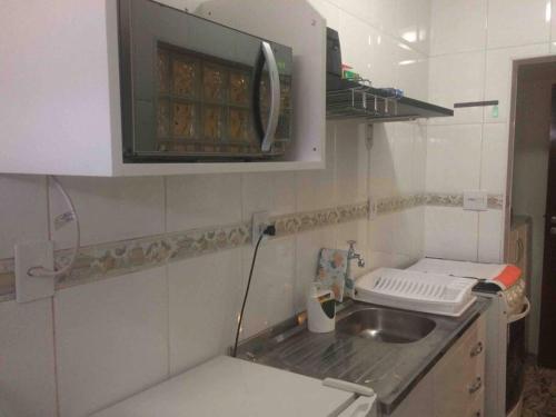 a small kitchen with a sink and a microwave at Studio 1608 in São Paulo