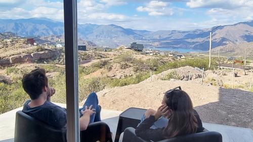 two women sitting in chairs looking out at the mountains at Piuquenes 2 in Potrerillos