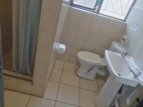 a bathroom with a toilet and a sink and a shower at The Royal Holiday Home in Port Shepstone