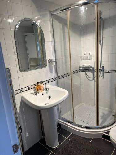 W łazience znajduje się umywalka i prysznic. w obiekcie The Farm House Modern spacious 2 bedroom home at Tong road Leeds perfect for contractors free secure parking w mieście Stanningley