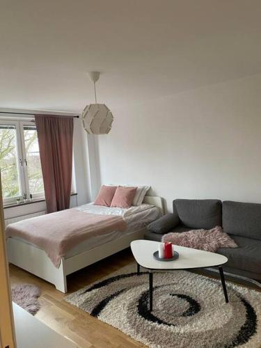 1 dormitorio con cama, sofá y mesa en A charming central one room apartment. en Malmö
