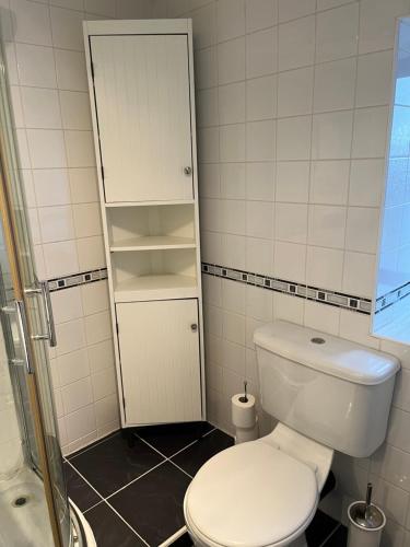 a bathroom with a white toilet and a shower at The Farm House Modern spacious 2 bedroom home at Tong road Leeds perfect for contractors free secure parking in Stanningley