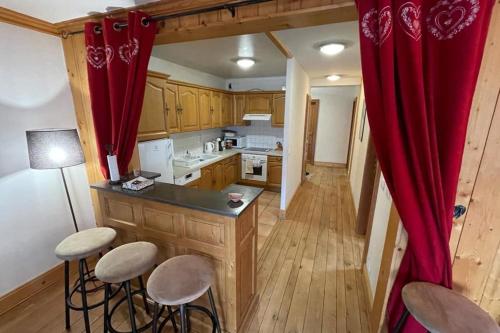 - une cuisine avec des placards en bois et un rideau rouge dans l'établissement Large apartment in Chamonix - close to the slopes, à Chamonix-Mont-Blanc