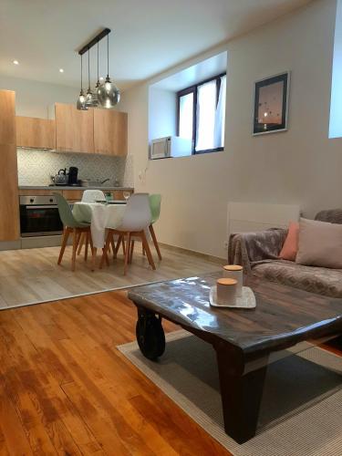 un salon avec un canapé et une table dans l'établissement Proche gare, cosy, courte et moyenne durée, à Bellegarde-sur-Valserine