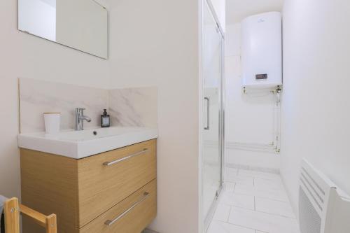 a bathroom with a sink and a shower at Appartement Familial - Avec Parking Privé Gratuit in Arras