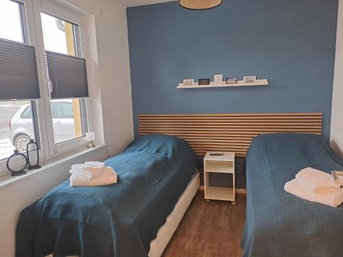 2 Betten in einem Zimmer mit blauen Wänden in der Unterkunft Ferienhaus Spreewaldliebe in Lübben