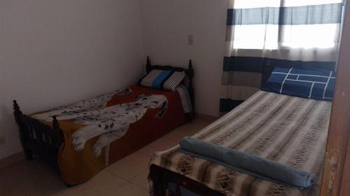 1 dormitorio con 2 camas y ventana en Paisajes en Monterrico