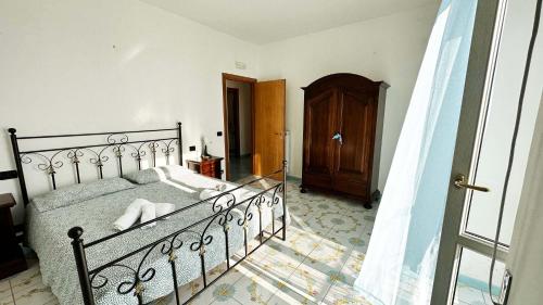 a bedroom with a bed and a wooden door at Dimora Alma camere panoramiche in Pianillo