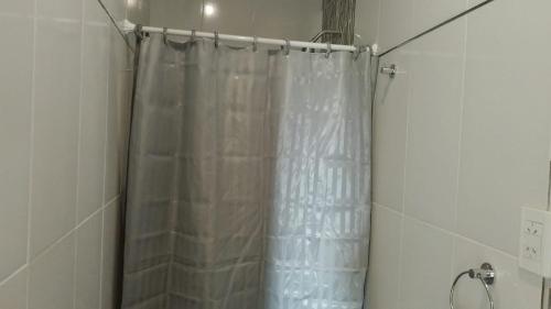 a shower with a shower curtain in a bathroom at Paisajes in Monterrico