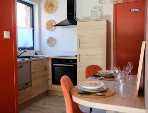 Wargnies-le-Grand的住宿－Suite Terracotta : Gîte de charme en Avesnois，一间带桌椅的厨房和一间用餐室