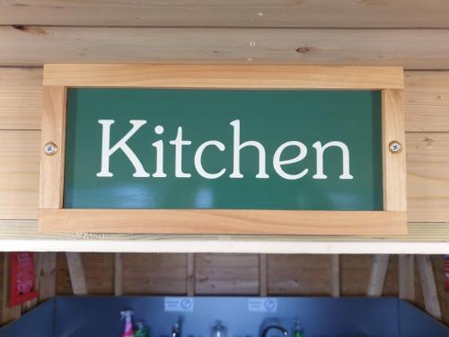 a chalkboard with the word kitchen on top of a shelf at Luxury 5m bell tent with log burner near Whitby in Saltburn-by-the-Sea