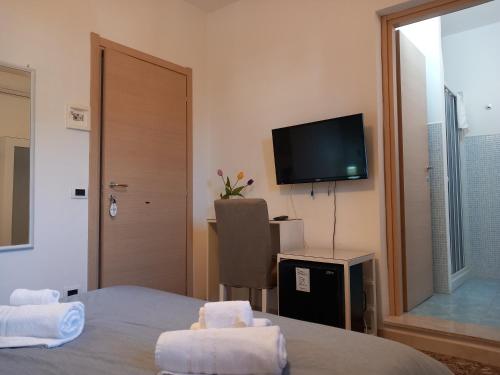 a hotel room with a bed and a flat screen tv at A due passi dal centro in Noto