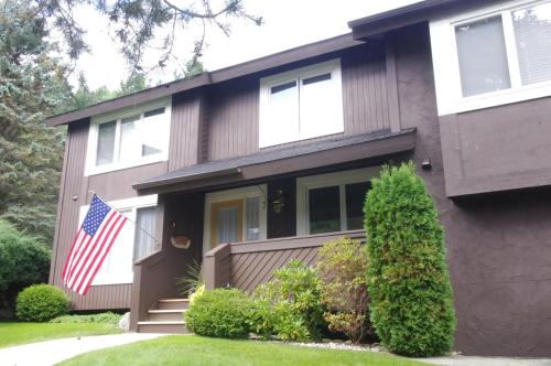 una casa con una bandera americana delante de ella en The Highlands at Harbor Springs, en Harbor Springs