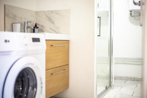 ein Bad mit einer Waschmaschine und einer Dusche in der Unterkunft Appartement Familial - Avec Parking Privé Gratuit in Arras