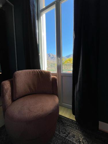 a living room with a chair and a window at Ostan Hôtel Boutique in Roquebillière