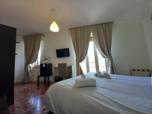 a bedroom with a white bed with two towels on it at A due passi dal centro in Noto