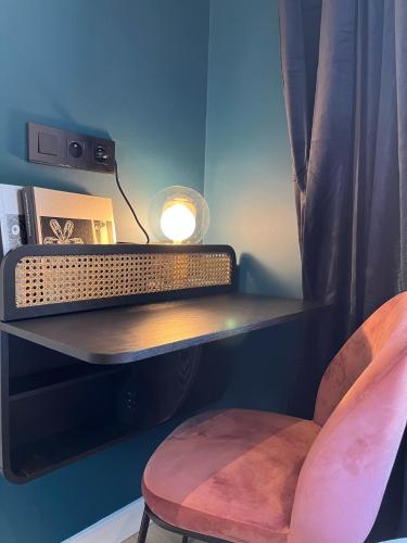 a desk with a lamp and a chair in a room at Ostan Hôtel Boutique in Roquebillière