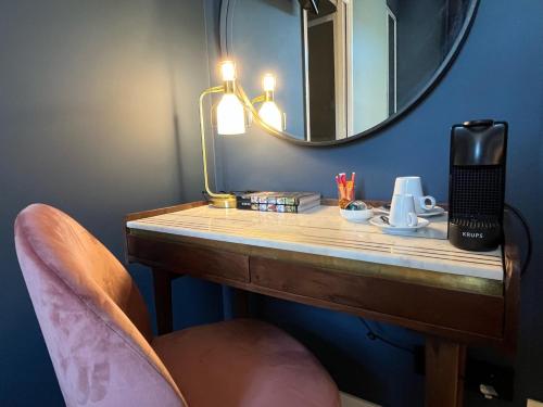 a bathroom with a vanity with a mirror and a chair at Ostan Hôtel Boutique in Roquebillière