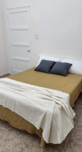 1 cama grande en un dormitorio con una pared blanca en Casa Isa en San Juan