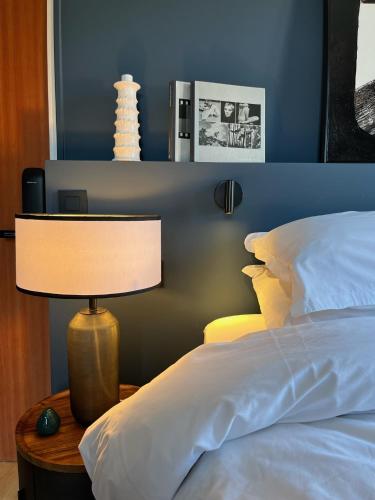 a bedroom with a bed and a lamp on a table at Ostan Hôtel Boutique in Roquebillière