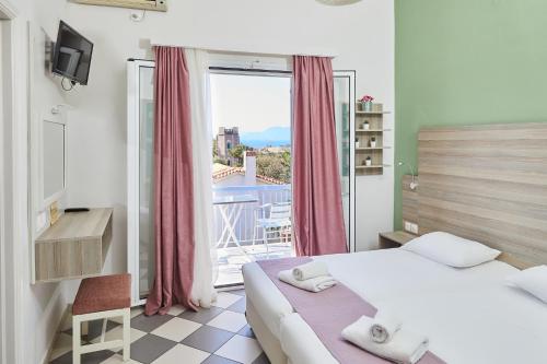 a bedroom with a bed and a window with a view at Klonos Anna in Aegina Town