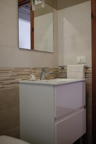 bagno con lavandino e specchio di Appartamento Maestrale a Torre Pali