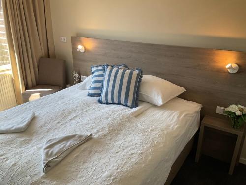 a bed with blue and white pillows on it at Fisherman's House by Hofstad Hotels in Scheveningen