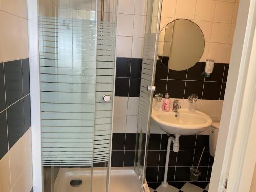 La salle de bains est pourvue d'une douche, d'un lavabo et de toilettes. dans l'établissement Fisherman's House by Hofstad Hotels, à Scheveningen
