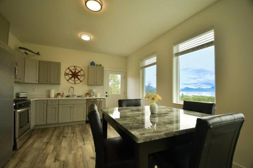 a kitchen with a table with chairs and a counter top at Rockfish Retreat at Kachemak Bay Kabins in Homer